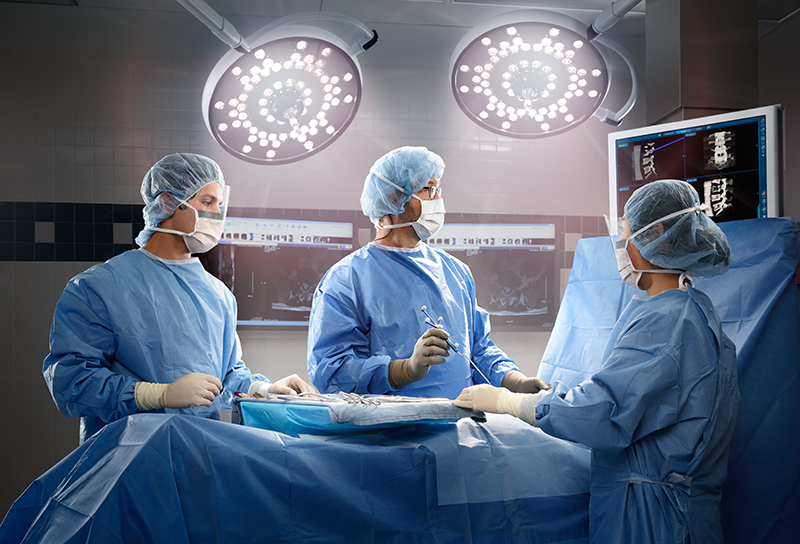 Spine specialists operating on a patient