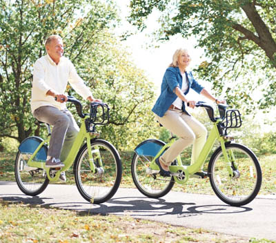 A couple riding bikes in park